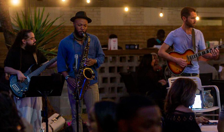 Customers enjoy live music while dinning in the patio area of Lucille's restaurant on Thursday, Oct. 15, 2020, in Houston. Lucille's has been hosting pop-ups in its patio for bars that have been closed during the pandemic. The restaurant provides the food, and the bar team pockets all of the money from the drinks.